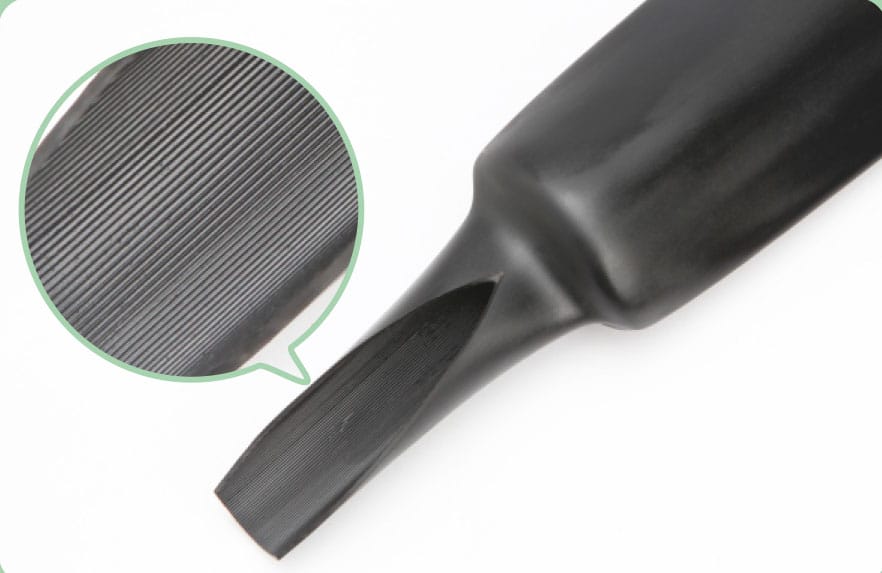 Part-recovered black GLC-SV tube photographed on white, with a circular magnified inset showing the fine parallel air-vent grooves running along its inner wall