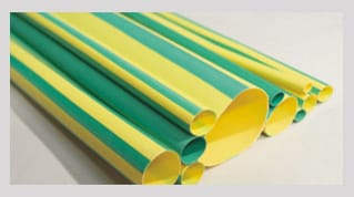 A stack of yellow and green striped heat shrink tube in several bores, cut ends facing the camera, lying flat in the supplied expanded state.
