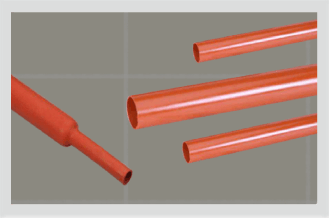 Four lengths of red heat shrink tube on a grey grid, three cut square to show the bore and one tapering down where it has recovered onto a smaller diameter.